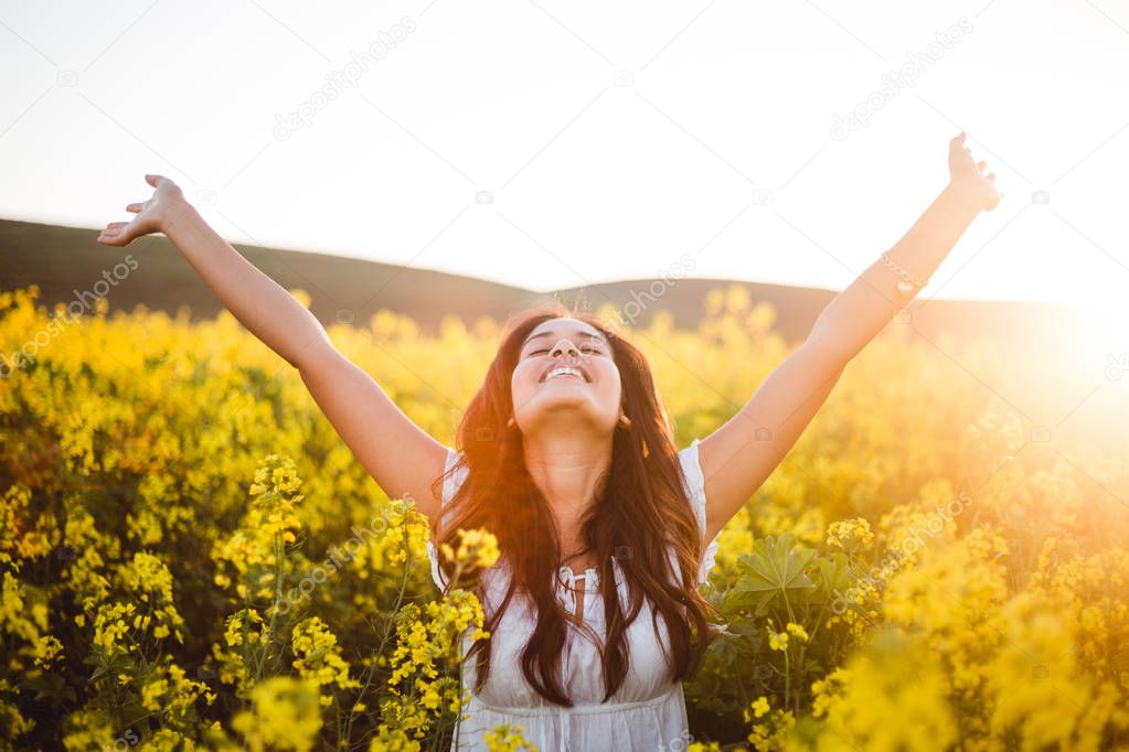 Teenage girl in yellow flowers field