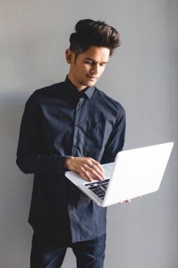 Genç adam dizüstü bilgisayar kullanıyor