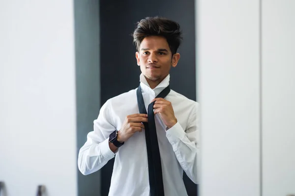 man getting dressed in mirror