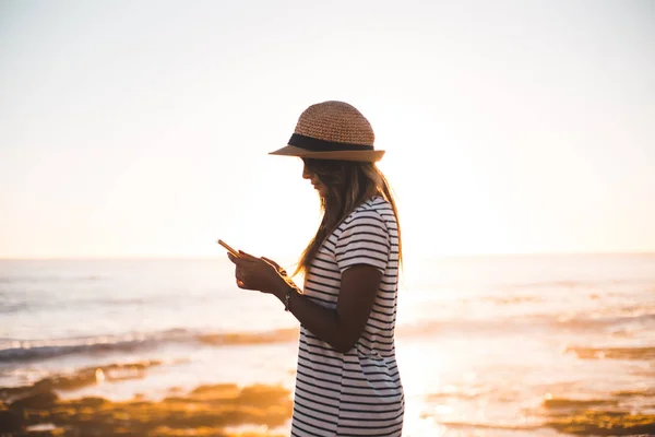 Mujer joven tomando fotos en la playa —  Fotos de Stock