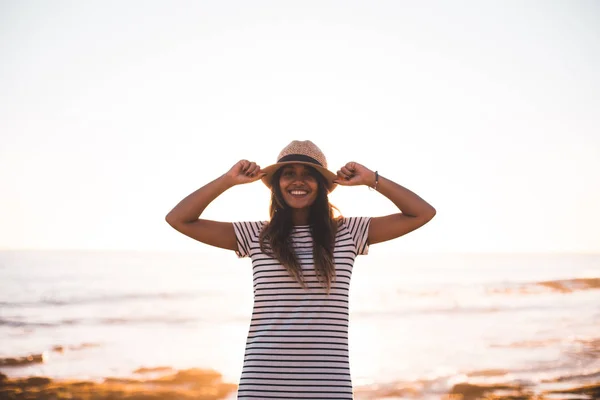 Wanita muda memegang topi di pantai — Stok Foto