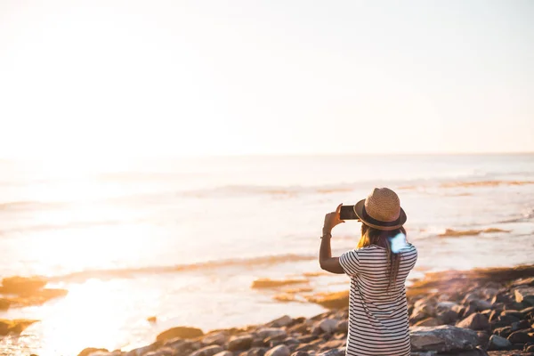 Молодая женщина фотографирует на пляже — стоковое фото