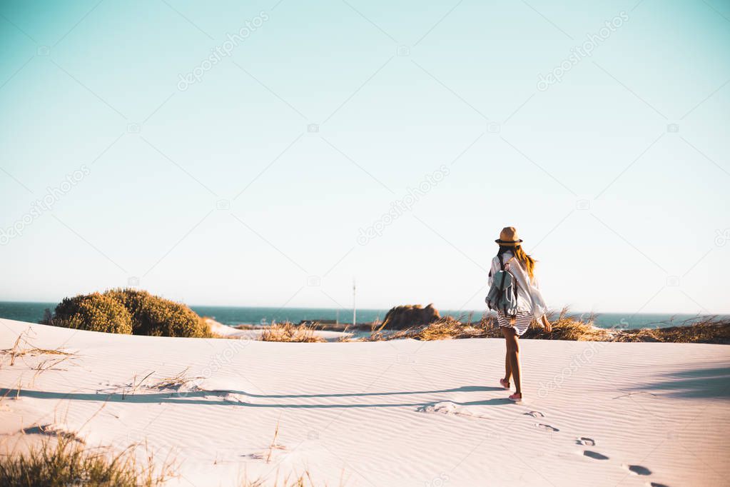 girl walking on sand dunes