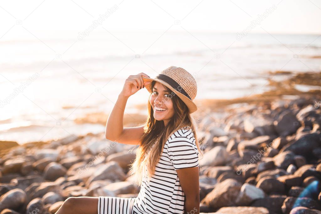 Young woman sitting on beach rocks