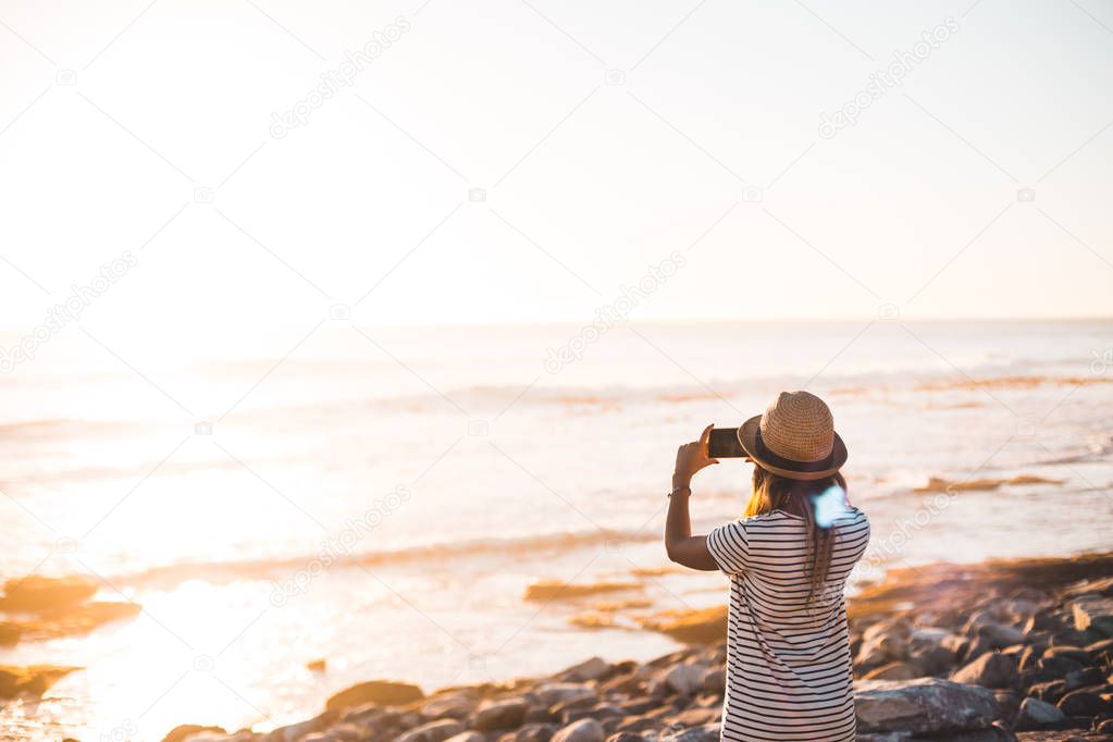 young woman taking photo on beach