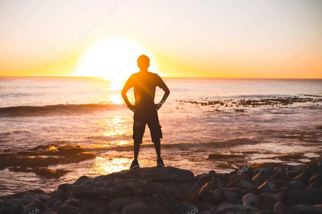 Young man silhouette against beach 