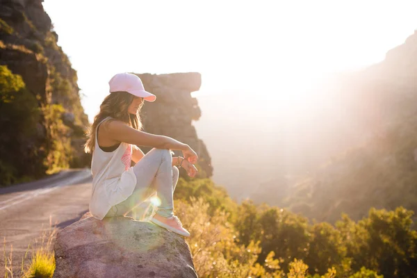 바위 위에 앉아 있는 젊은 여자 — 스톡 사진