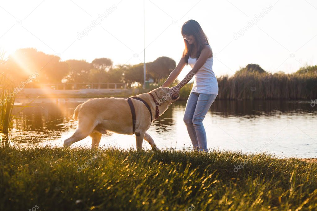 young woman playing with Labrador dog