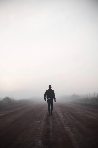 Man walking away on misty road — Stock Photo, Image