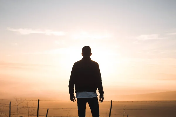 Silhouette man watching sunrise Stock Picture