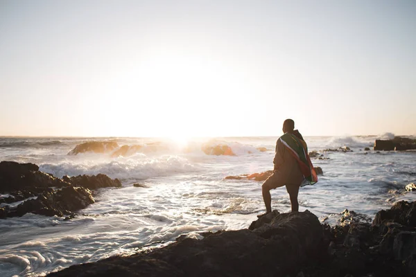 Man insvept i flaggan på havsstranden — Stockfoto