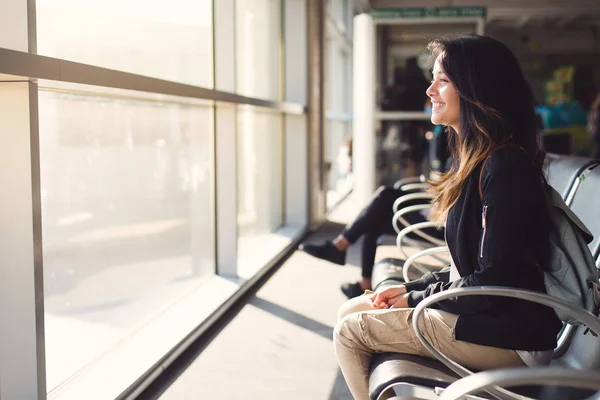 Wanita yang duduk di bandara dan menunggu pesawat — Stok Foto