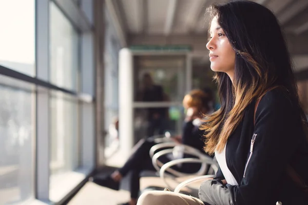 Havaalanında oturuyor ve uçak için bekleyen kadın — Stok fotoğraf