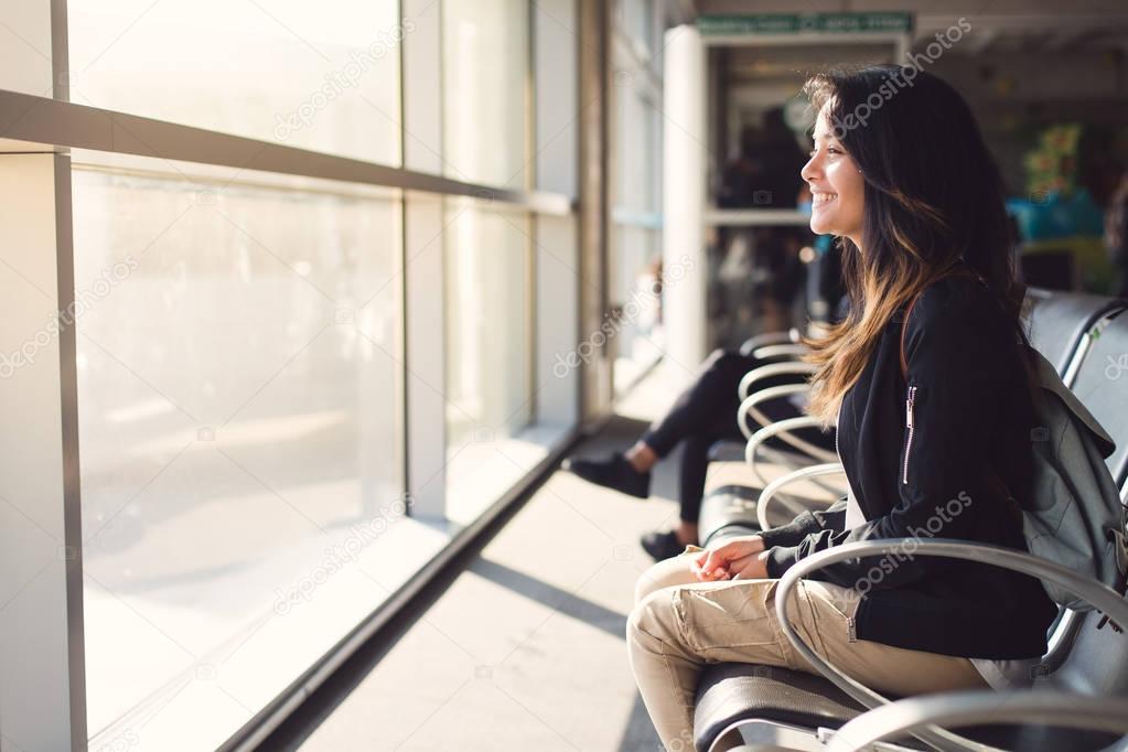 woman sitting at airport and waiting for plane