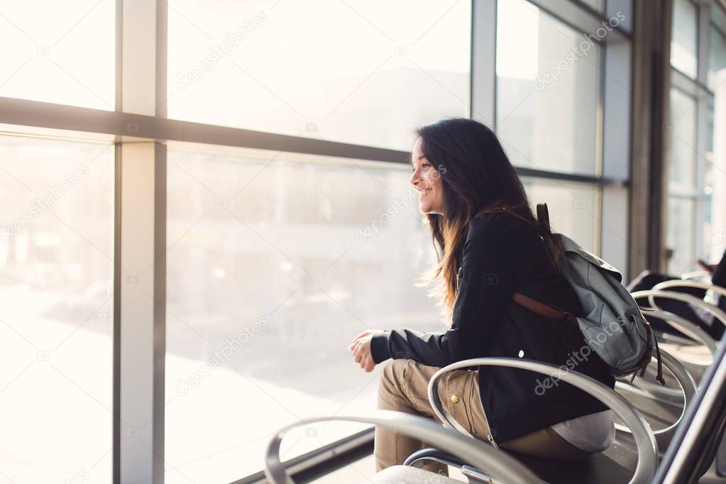 woman sitting at airport and waiting for plane