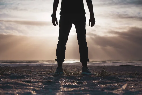 Человек, стоящий на песчаном пляже — стоковое фото