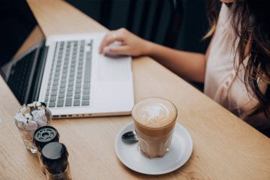 El ile cam fincan kahve closeup görünümünü arka plan üzerinde laptop