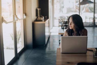 Pencere kapı laptop kafede çalışırken genç karışık yarış kız görünümünü