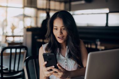 Onun smartphone vasıl kafede otururken genç karışık yarış kız önden görünümü