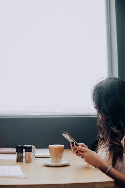Chica Joven Raza Mixta Usando Teléfono Inteligente Mientras Está Sentado — Foto de Stock