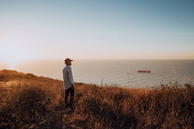 şehrin yukarısındaki kayada duran adam 