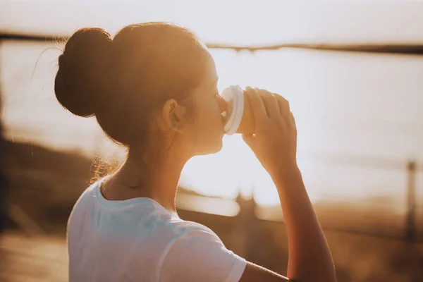 Frau Trinkt Kaffee Bei Sonnenuntergang Nahaufnahme Glücklich Kaffee Trinken Seebrücke lizenzfreie Stockbilder