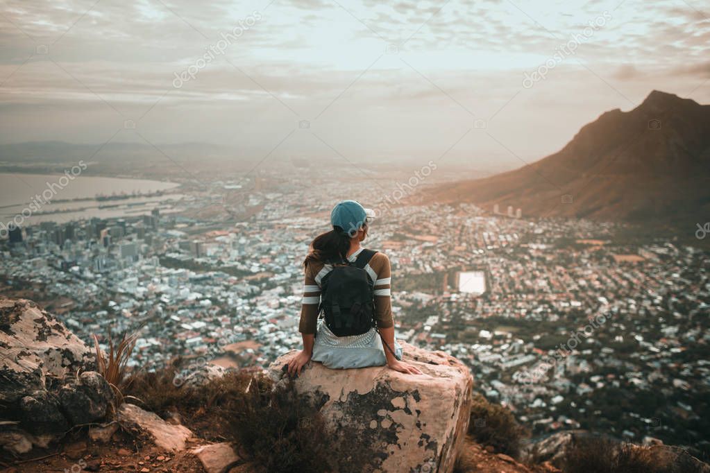 woman hiker in mountains above the city 