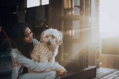 Terasta oturan bir köpekle çekici kadın