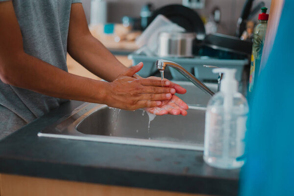 Young person washing hands using sanitizer