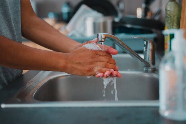 Young person washing hands using sanitizer