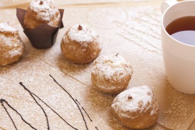 Ambalaj için kahverengi kağıt üzerinde Profiteroles, krem şanti ile kek.