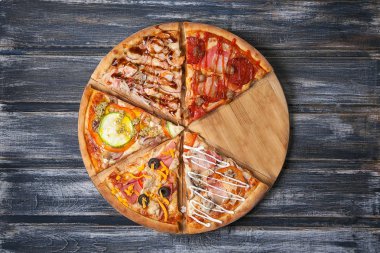 Pizza yapıldığı malzemelerle ahşap bir masa üzerinde.