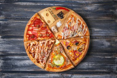 Pizza yapıldığı malzemelerle ahşap bir masa üzerinde.