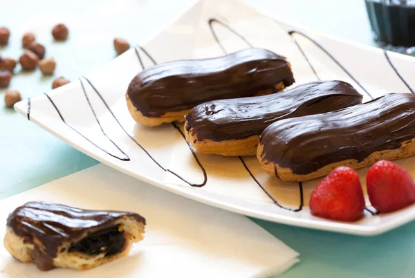 Çikolata Fındık Çilek Mavi Peçete Üzerinde Çay Ile Eclairs — Stok fotoğraf