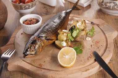 Alabalık biftek fırında patates sarımsak, biberiye ve vagetables ahşap tahta üzerinde.