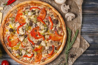 Dilim pizza olmadan tek parça, farklı tatlar ile ahşap bir masaya kesilmiş