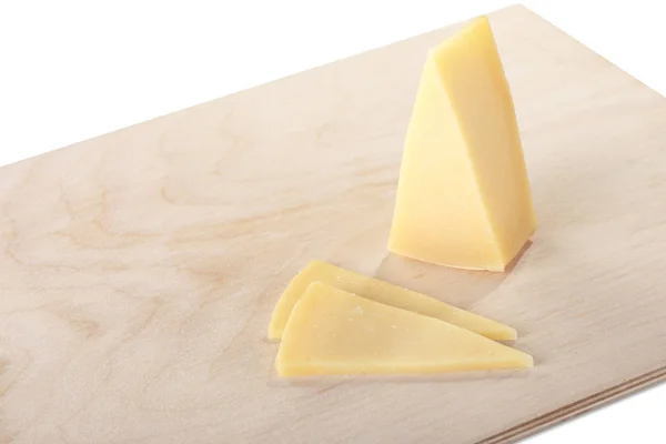Bloc de fromage avec morceaux découpés sur une planche à découper, isolé sur fond blanc — Photo