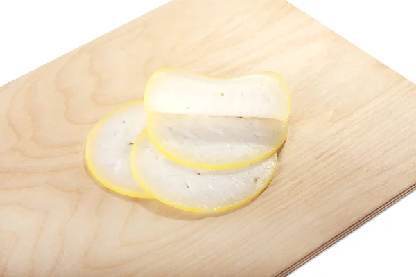 Μπλοκ του τυριού με κομμένα κομμάτια σε ένα ξύλο κοπής, απομονώνονται σε λευκό φόντο — Φωτογραφία Αρχείου