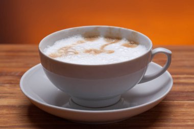 ahşap arka plan ile karanlık tabloda beyaz fincan kahve.