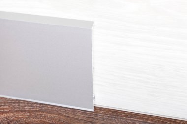 Üzerinde süpürgelik yüklü bir ahşap duvar