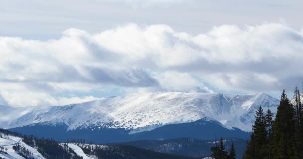 Un amas de nuages se déplace sur les montagnes enneigées du Colorado, ce qui en fait une journée sombre .