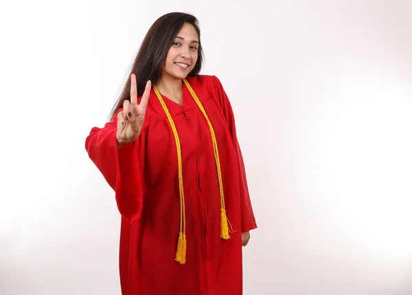 Mezun olmuş bir öğrenci elinde barış işareti tutuyor..