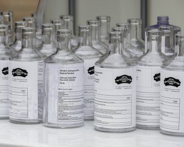 Houston, TX - 31 Mart 2020 Whitmeyer 's Distilling Co.' da boş cam şişeler halka dağıtmak için el dezenfektanı ile doldurulmayı bekliyor..