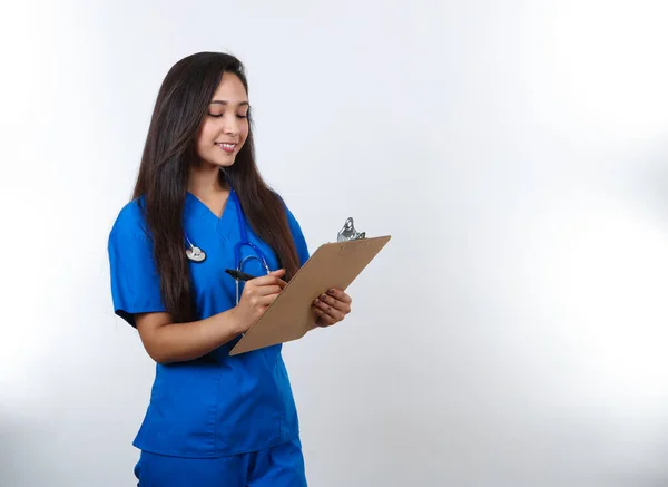 Eine Hübsche Krankenschwester Blauem Peeling Schreibt Notizen Auf Ihr Klemmbrett — Stockfoto