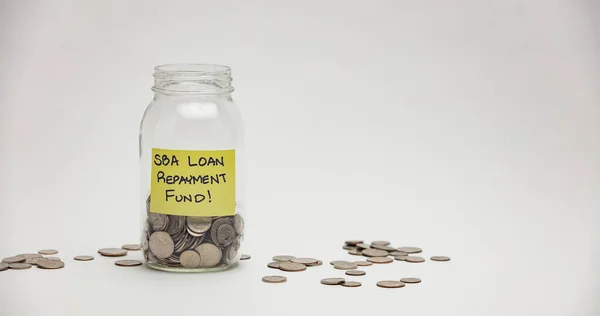 Bir cam kavanozda SBA kredisinin geri ödemesi için çok sayıda çeyreklik, on sent ve nikel bulunur..