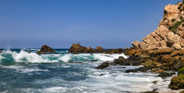 Meksika, Jalisco 'daki Mayto Sahili' nden Pasifik Okyanusu 'nun inanılmaz manzarası. Dalgalar doğal kaya oluşumlarına çarpıyor..