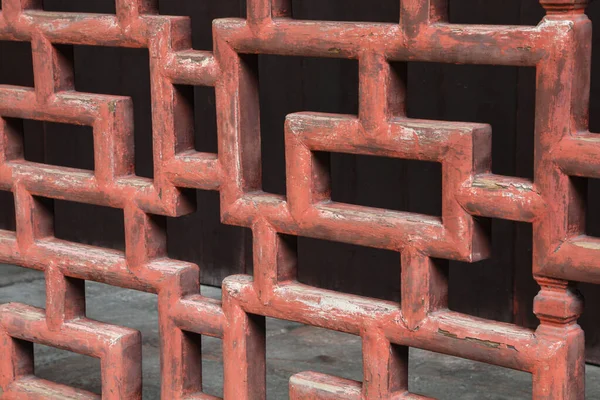 Çin 'de bir bahçede bulunan eski kırmızı yıpranmış Çin ahşap işçiliğinin yakın çekimi..