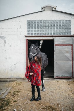 Ahırda atlı bir kız.
