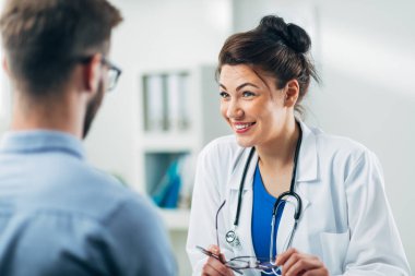 Doktor ve hasta doktorun ofisinde oturuyor.