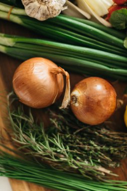 Mutfaktaki tahta kesme tahtasında çeşitli sebzeler var.